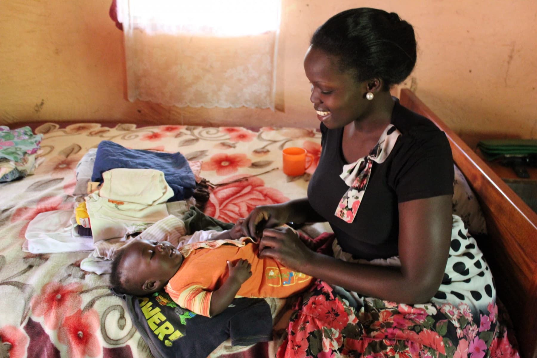 A midwife smiling with a mother and her newborn at the birth center